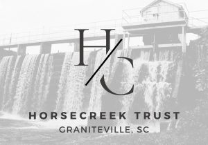 Black and white image of a large dam with flowing water. The foreground features the logo "HC" and text reading "Horsecreek Trust, Graniteville, SC" over the image.